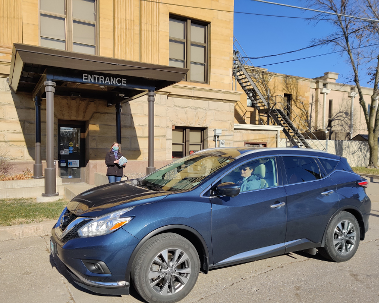 Person in car waiting for curbside pickup at the library