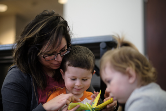 Woman reading book to toddlers