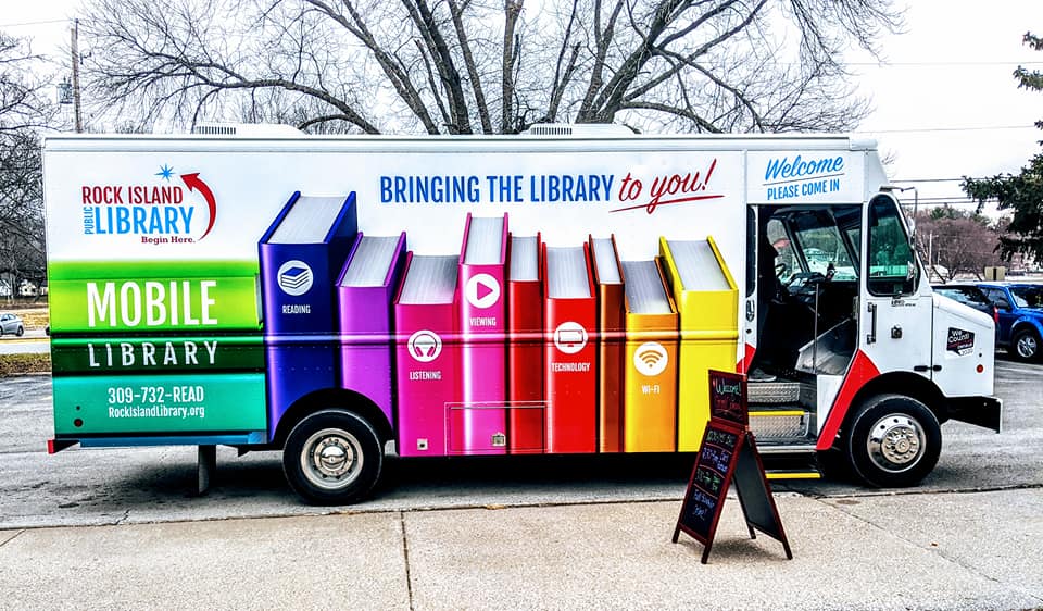 Picture of the side of the mobile library showing the library's logo and colorful book spines.