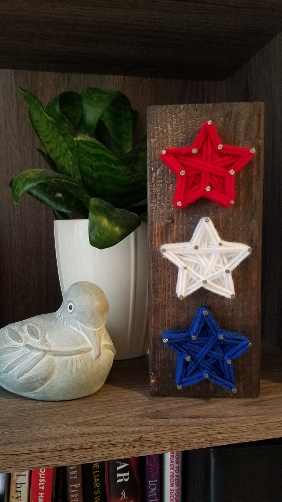Red, White, and Blue yarn stars sitting on table.