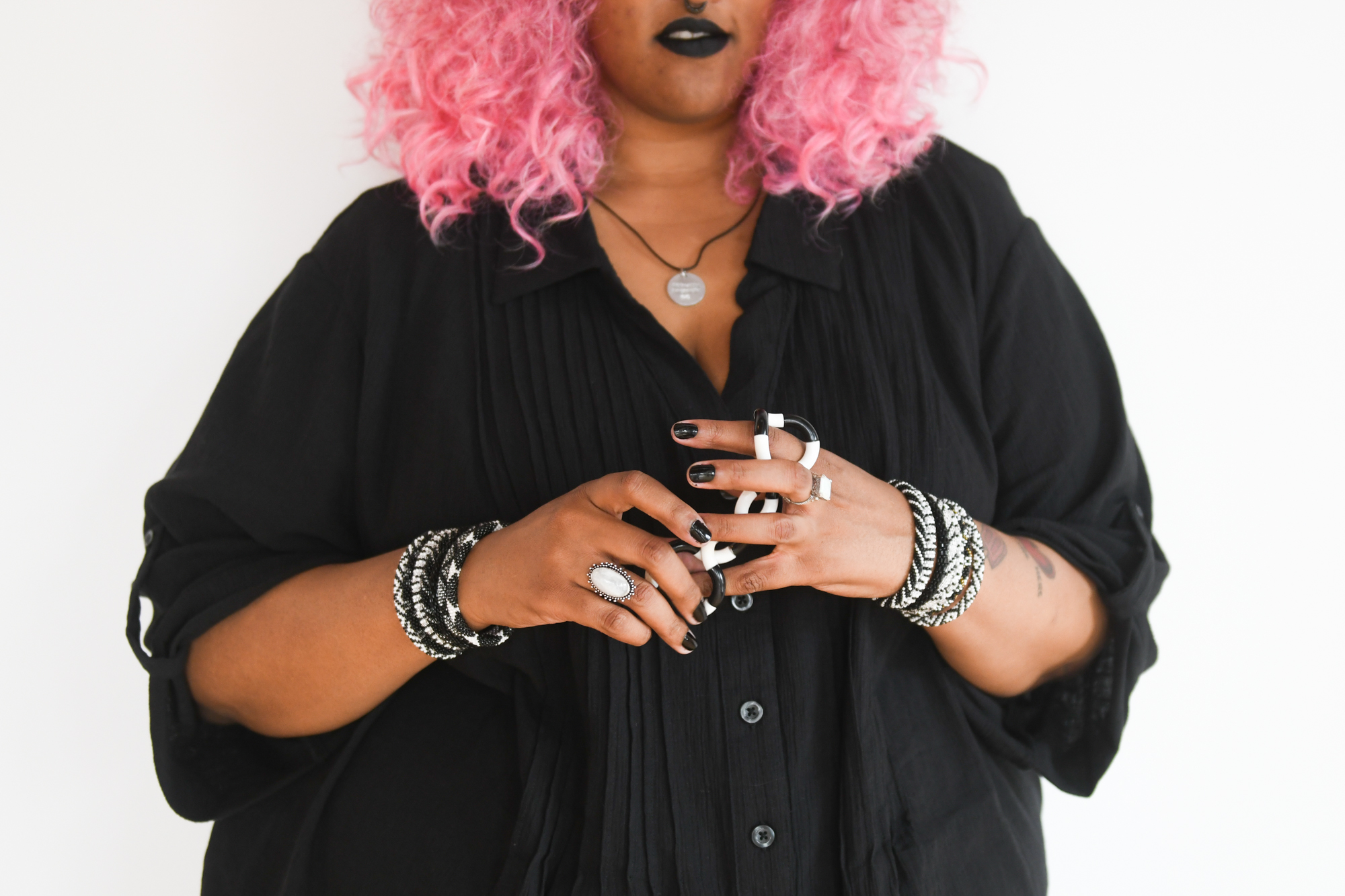 An African American teen with pink hair wears multiple bracelets.