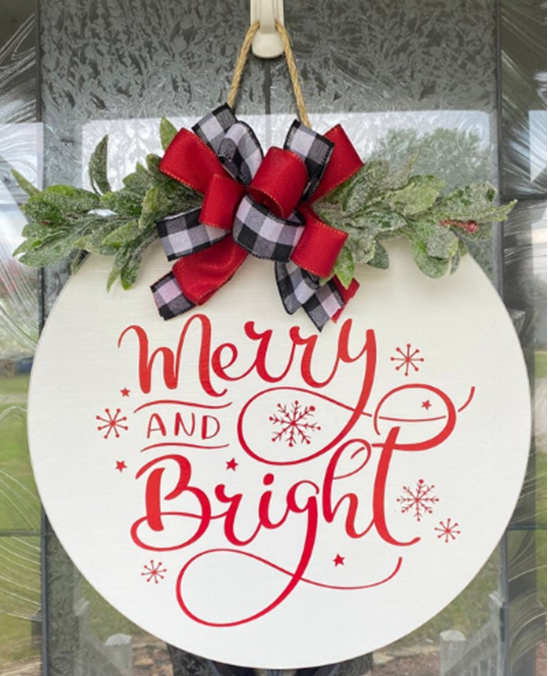 Wall hanging with Merry and Bright on it, plus greenery and Christmas ribbon.