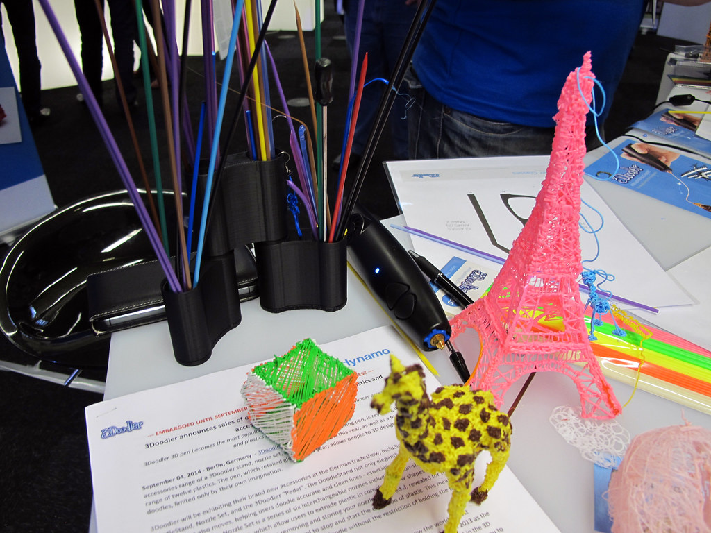 A pink Eiffel tower and other colorful 3-D printed items, including filaments of different colors.