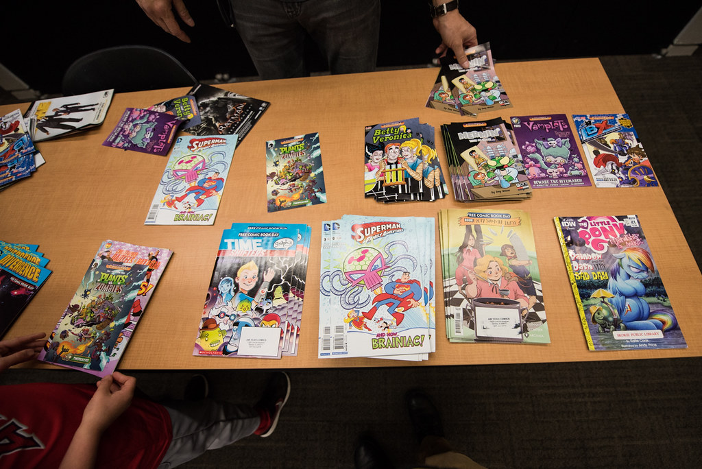 An image of a tan table covered with a display of free comic books.