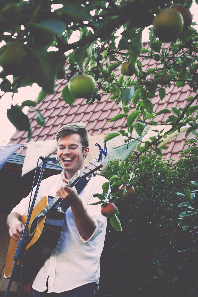 Lewis Knudsen playing guitar in garden