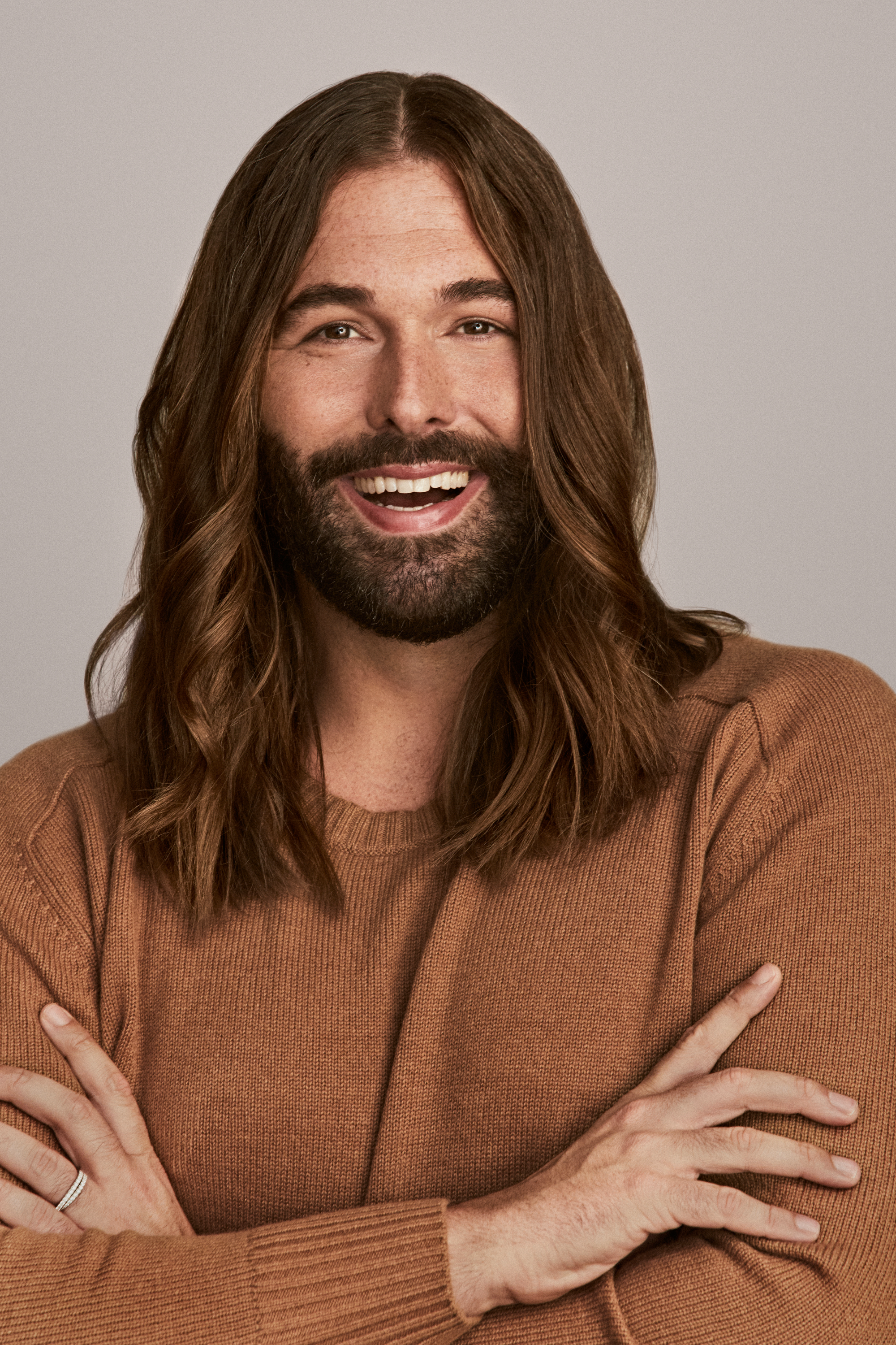 Jonathan Van Ness author portrait_long haired man in rust colored sweater arms folded