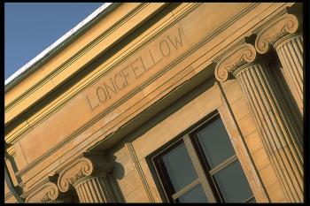 Closeup of author name frieze at the top of the building reading "Longfellow"