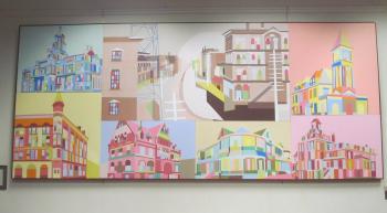 Mural of various buildings and city scenes painted in bright blocks of color