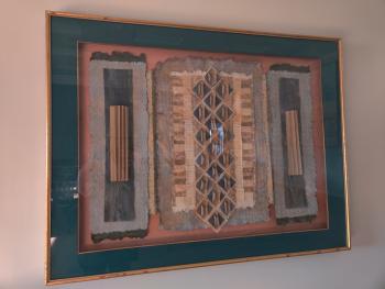 Framed pattern in mixed media, including rolled, folded, and torn paper