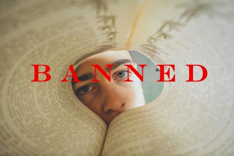 Child peering through curved book pages stamped with 'Banned'
