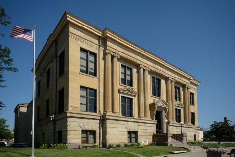 Exterior photo of the Rock Island Downtown Library with flag flying
