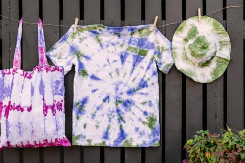 Purple and pink tie dyed bag, glue and green tie dye shirt, green tie dyed hat