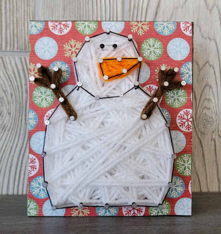 black and white string art snowman with wintery background