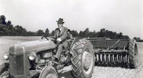 Henry Ford riding one of his tractors