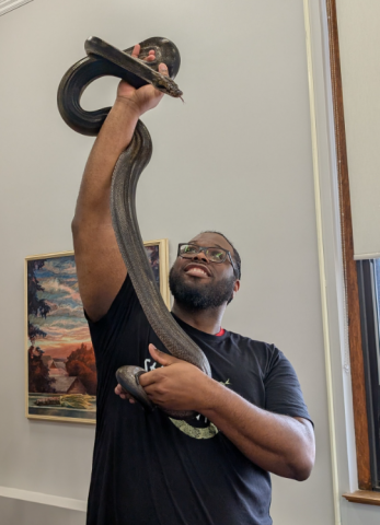 Jonathan holding a large to length over his head. 