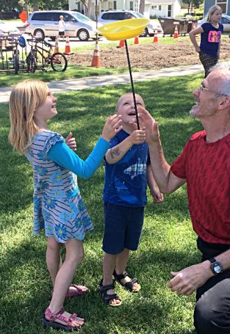 Photo of kids balancing spinner plates with Mark Hanson at an outdoor event