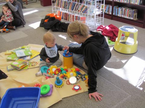 Photo of child playing with mother at event. 