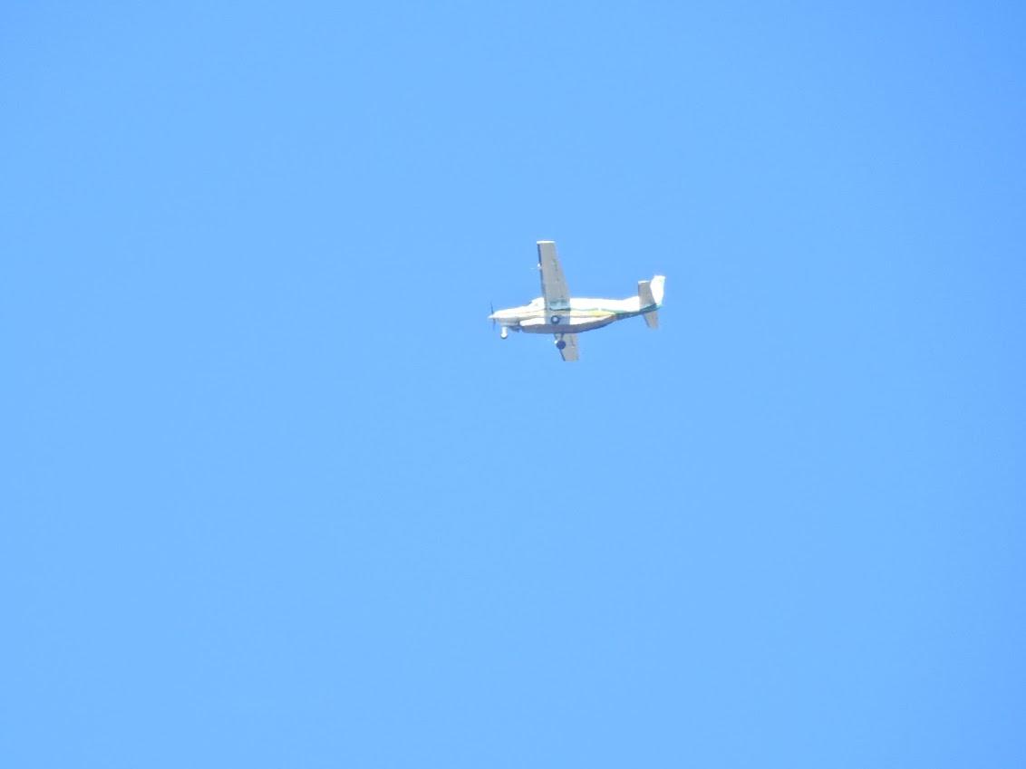 Small plane flying with blue sky background.