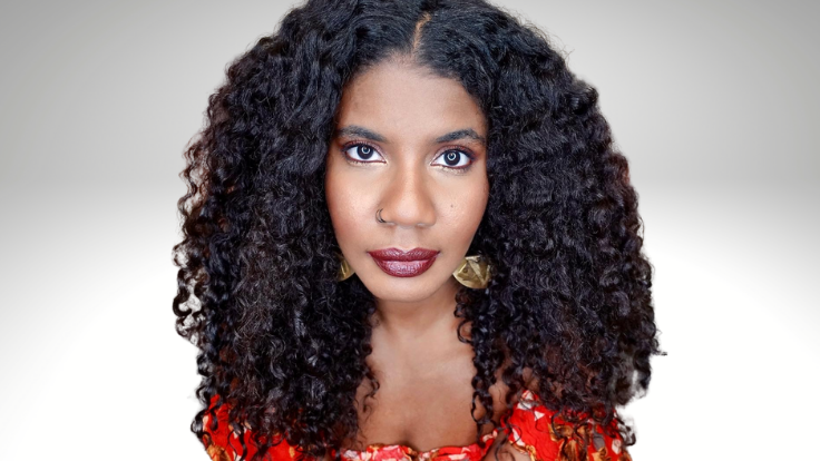 Image of author Nic Stone wearing a red shirt.