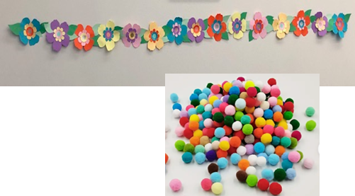 Paper flowers strung together in a garland with pom-poms for center of flowers.