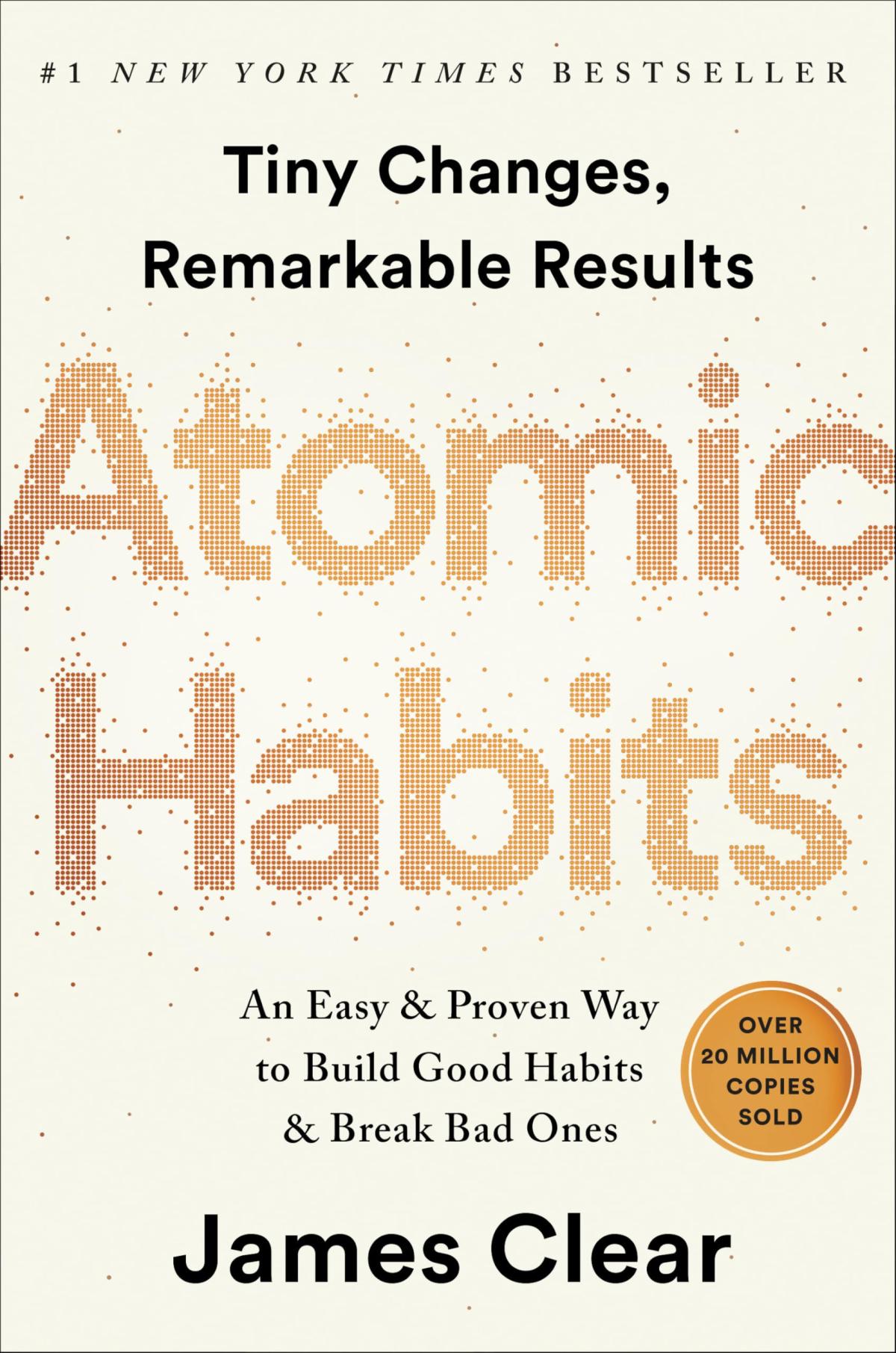 Tan and gold book cover of "Atomic Habits" by James Clear