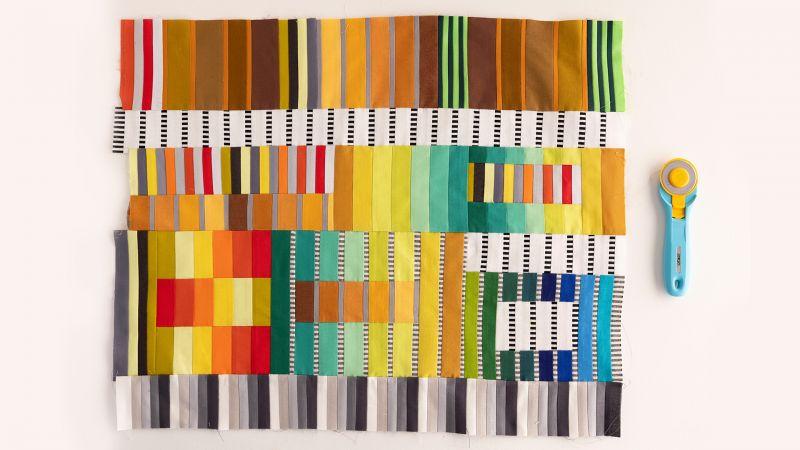 Fabric construction into a quilt top that has the appearance of ribbons by Sarah Bond.