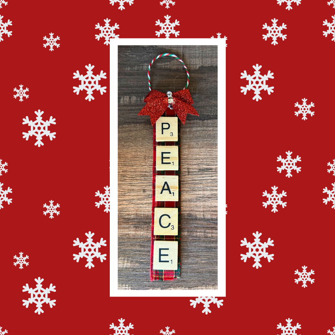 Photo of letter tile ornament craft against a red background with white snowflakes