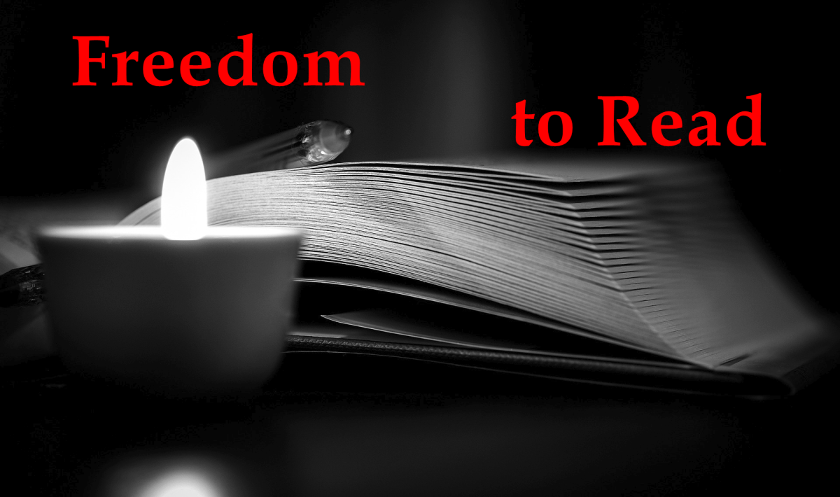 A book illuminated by a candle with a pen resting on the left page