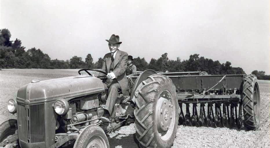 Henry Ford riding one of his tractors