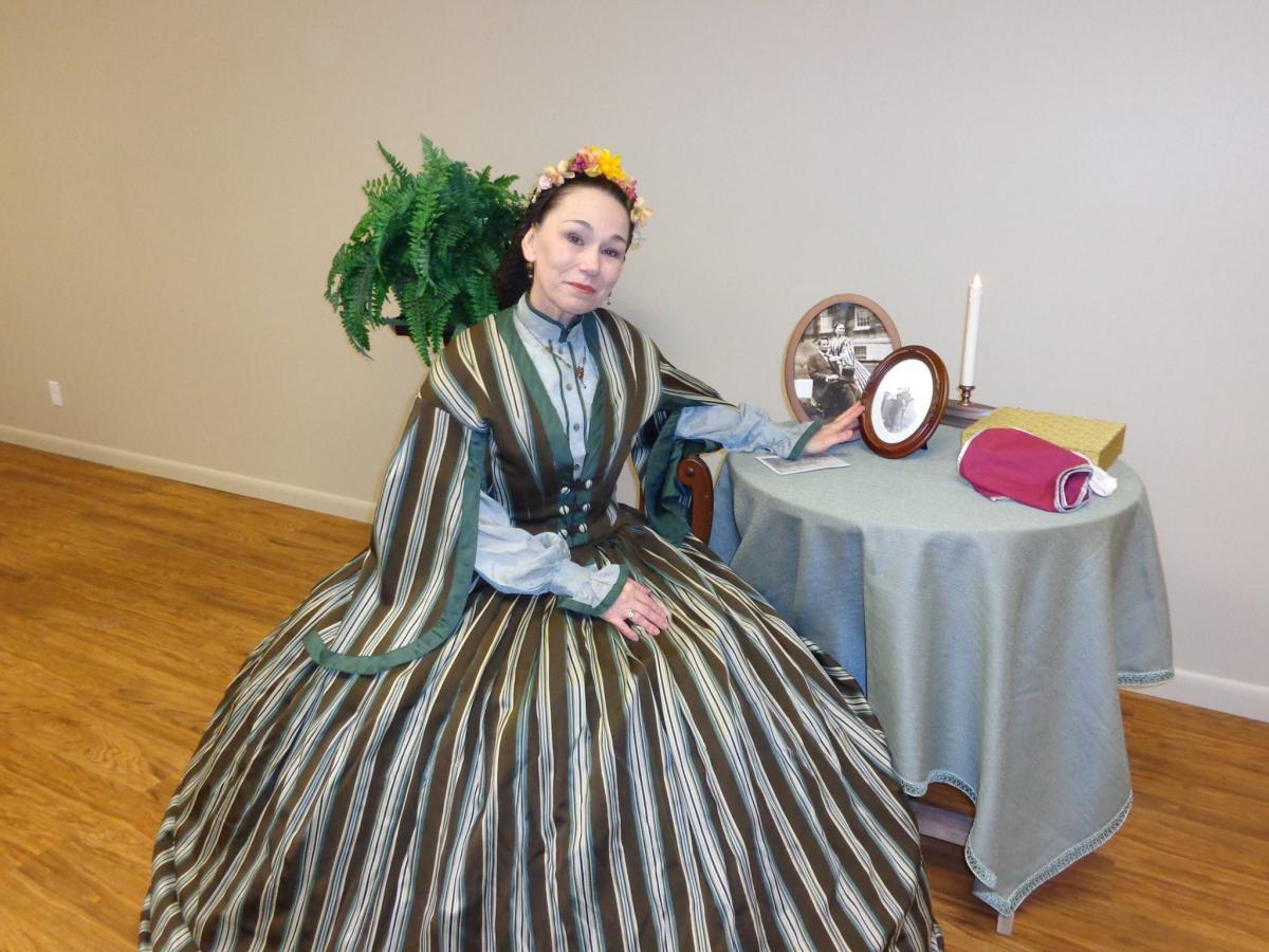 Image of a woman in period attire sitting at a small table